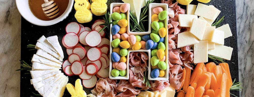 charcuterie board with easter candy on a marble background